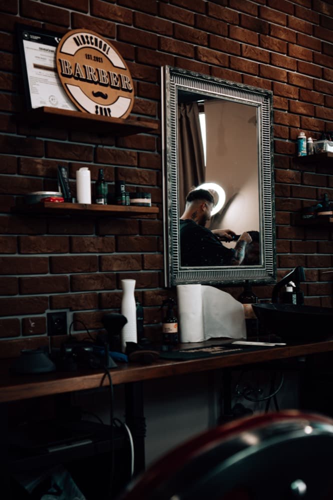 Zrkadlo a polica s produktmi v barbershope